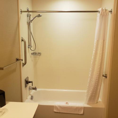 a bathroom with a bath tub with a shower curtain at Comfort Suites-Youngstown North in Youngstown
