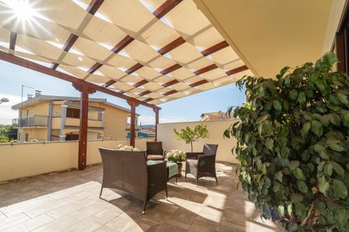 a patio with a table and chairs and a plant at Domo Papiros B&B in Siniscola