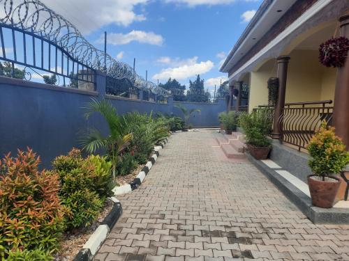 a brick walkway in front of a house with plants at Deerwood Family Apartments, Bulenga in Bulenga
