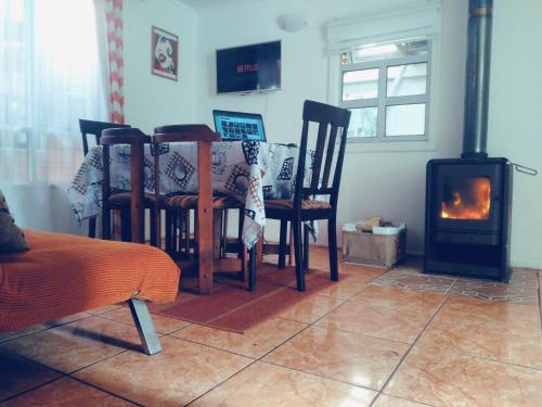 a dining room with a table and a wood stove at Casa Valle Volcanes 3 Dormitorios in Puerto Montt