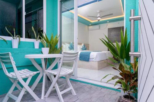 a balcony with a table and two chairs and a bed at Ukulhas Sands in Ukulhas