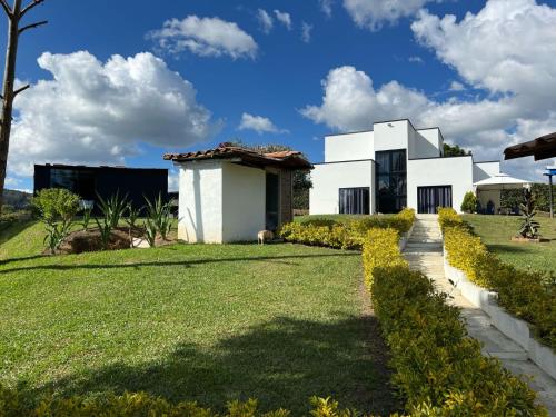 San VicenteにあるFinca Oriente Antioqueño -A 40 minutos de Medellínの芝生の庭のある白い家