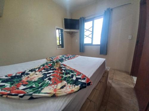 ein Bett mit einer Decke in einem Schlafzimmer in der Unterkunft Pousada Belas Praia quarto Praia d'água in Imbituba