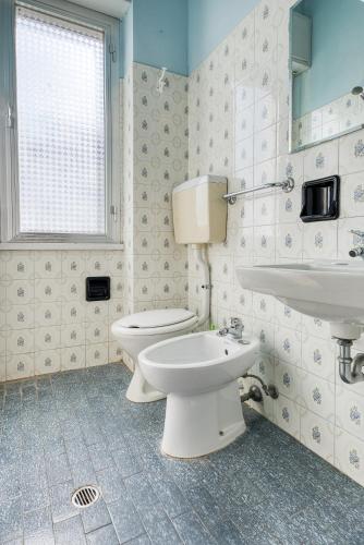 a bathroom with a white toilet and a sink at Hotel Sabbia d'Oro in Rimini