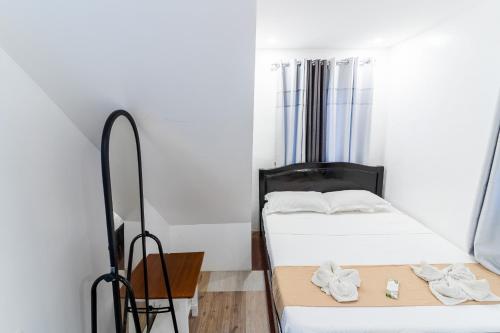 two beds in a small room with white walls at OCEANVIEW HOMESTAY in Alaminos