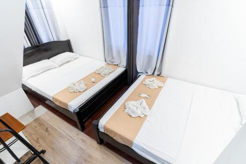 two beds in a small room with windows at OCEANVIEW HOMESTAY in Alaminos