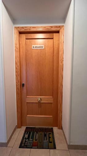 a wooden door with a welcome mat in front of it at CA LIDIA - Apartamentos Turisticos EL BALCONET in Benimantell