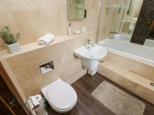 a bathroom with a toilet and a sink and a tub at Bumble Cottage in Holmfirth
