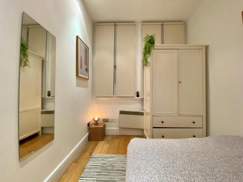 a bedroom with a bed and a white cabinet at One-bed flat Central London Payment required STRAIGHT away The host will message you after you've made a reservation in London