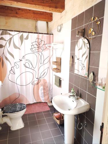 a bathroom with a sink and a toilet and a shower curtain at OnTheRocks - Holiday Home in Victoria, Gozo in Victoria