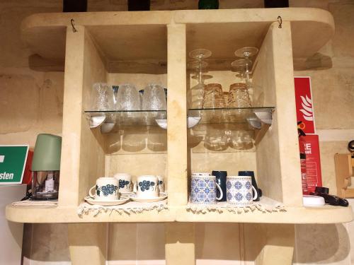 a wooden cabinet with cups and dishes on it at Charming House in Victoria, Gozo in Victoria