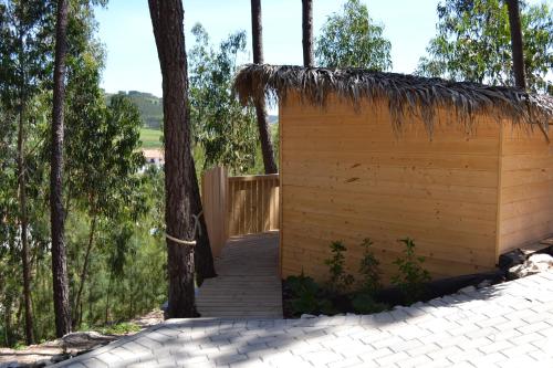 a small wooden building with a thatch roof at MountView in Alenquer