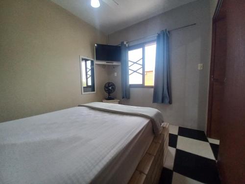 Schlafzimmer mit einem großen weißen Bett und einem Fenster in der Unterkunft Pousada Belas Praia quarto Praia do Porto in Imbituba