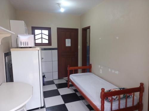 a small room with a small bed in a kitchen at Pousada Belas Praia quarto Praia do Porto in Imbituba