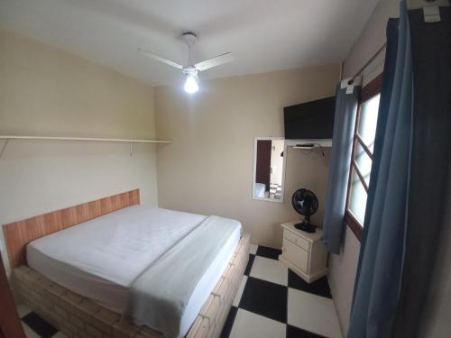 a bedroom with a bed and a black and white checkered floor at Pousada Belas Praia quarto Praia do Porto in Imbituba