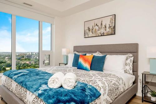 una camera da letto con un grande letto con due asciugamani di Newly Built Condo w Amazing Amenities and Views a Kitchener