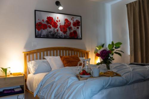 Una cama con una bandeja de comida y flores. en Epiphany homes, en Horsford