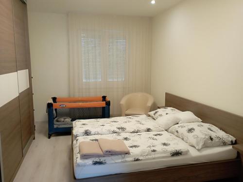 een slaapkamer met een bed, een stoel en een raam bij Thaly 5/1 in Debrecen