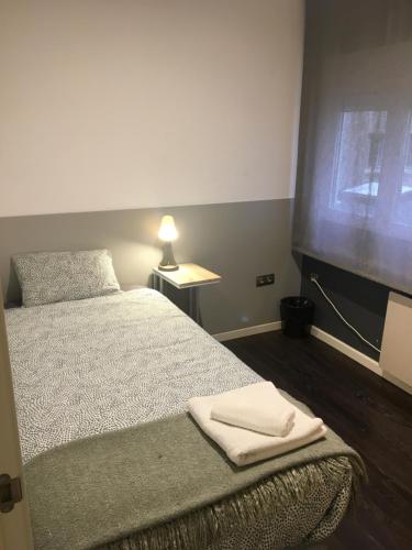 a bedroom with a bed with two towels on it at Apartamento Manuela Sancho in Zaragoza