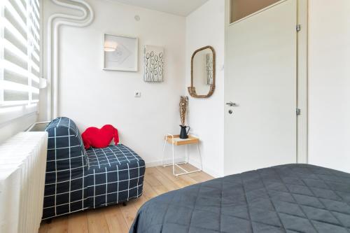 a bedroom with a bed and a chair and a mirror at Green Oasis in Banja Luka
