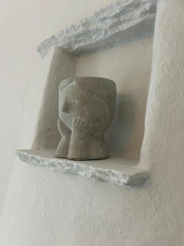a statue of a head on a wall at Lithari Traditional Apartment in Agios Sostis
