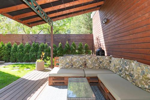 a couch sitting on a patio under a wooden wall at Cozy apartments by the river near old town in Kaunas