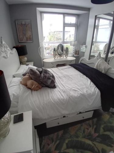 a bedroom with a white bed and two windows at Cosy Caroline's in Plymouth