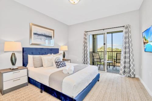 a bedroom with a blue bed and a balcony at Spacious 3BR Near Disney - Pool and Hot Tub! in Orlando
