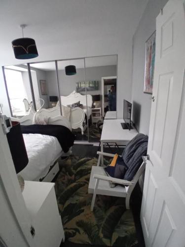 プリマスにあるCosy Caroline'sのベッド2台と鏡が備わる客室です。