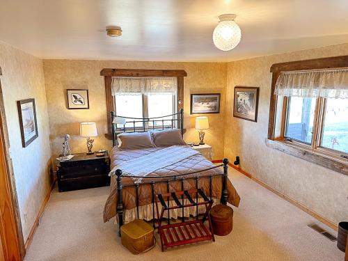 a bedroom with a bed and two windows at The Shepherd's Retreat in Livingston