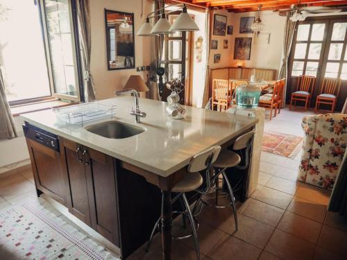 a kitchen with a sink and a counter with stools at Orman İçinde Muhteşem Villa in Kayakoy