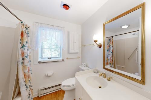 een witte badkamer met een wastafel en een spiegel bij The CAVU Mansion on Bellevue in Oklahoma Heights