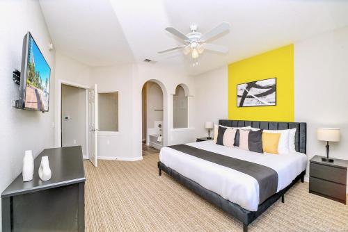 a bedroom with a large bed and a tv at Cozy 2BR Condo - Private Balcony - Near Disney in Orlando