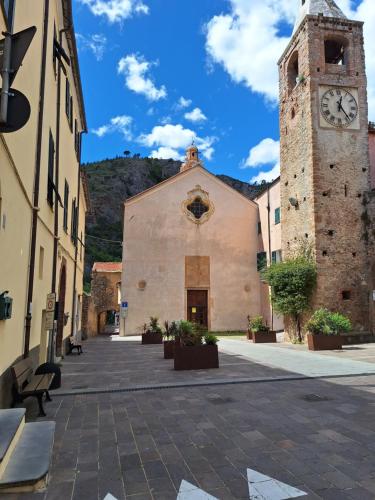 a building with a clock tower in a courtyard at Casa Iris in Cisano sul Neva