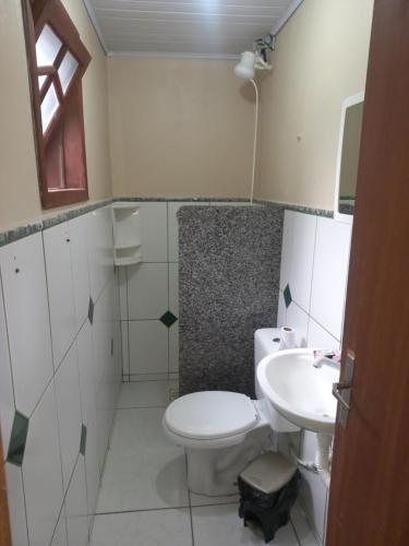 a bathroom with a toilet and a sink at Pousada Belas Praia quarto Praia da Vila in Imbituba