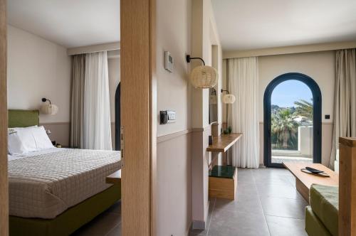 ein Hotelzimmer mit einem Bett und einem Fenster in der Unterkunft Loadstar Rooms & Suites in Kontokali