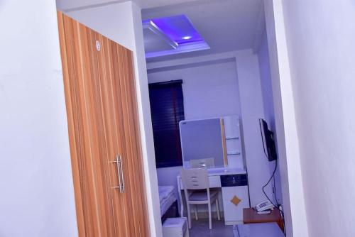 a room with a bathroom with a sink and a desk at THRIVEMAX HOTEL AND SUITE in Lagos