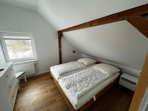 a small bedroom with a bed and a window at Landhaus-Ferienwohnung am Fluss in Plattenburg