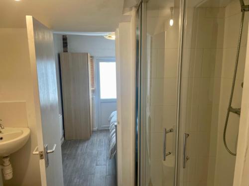 uma casa de banho com um chuveiro e um lavatório. em Rooms at EEJ homes em Londres