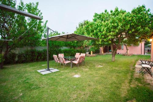 een tafel en stoelen onder een paraplu in een tuin bij Casa di Marco e Kaila in Tavullia