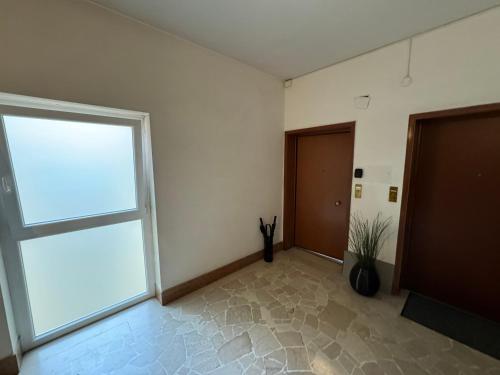 an empty room with a large window and two doors at Florence Modern Apartment SELF CHECK-IN in Florence