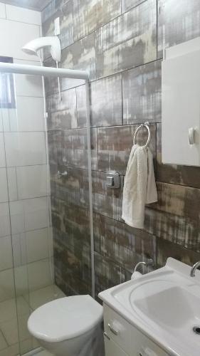 a bathroom with a white toilet and a sink at Casa De Praia Galheta in Farol de Santa Marta