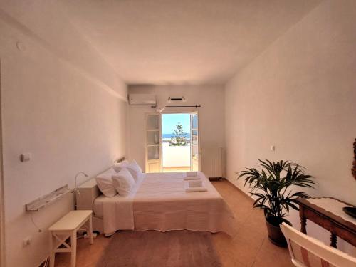 een grote witte kamer met een bed en een raam bij ASIA in Ermoupoli