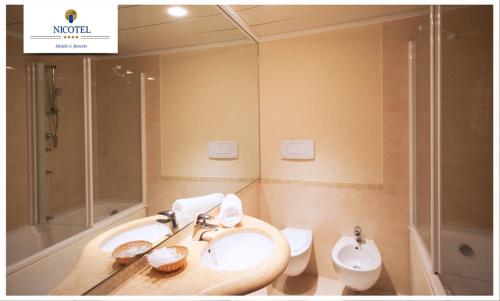 bagno con lavandino e servizi igienici di Nicotel Pineto a Castellaneta Marina