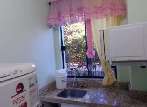 um balcão de cozinha com um lavatório e uma janela em Pousada Termas Piratuba em Piratuba