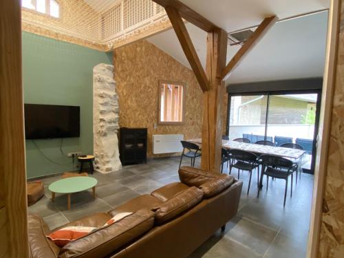 a living room with a couch and a table at Grange rénovée, 6 minutes du Lac d'Annecy vue sur le Mont-Blanc in Giez