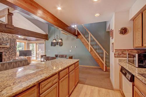 cocina con escalera y sala de estar. en Sawmill Creek Condo 309 by Great Western Lodging en Breckenridge