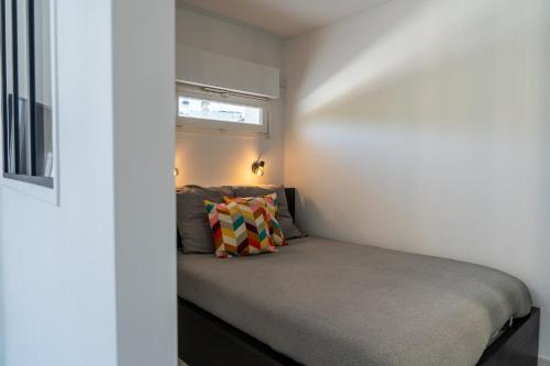 - une petite chambre avec un lit et une fenêtre dans l'établissement Appartement en bord de lac, à Aix-les-Bains