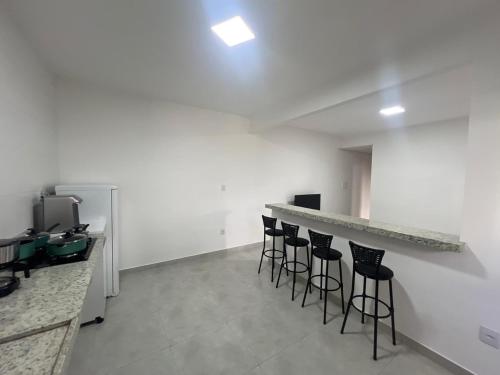 Habitación con barra con taburetes y mostrador en Executivo Veneza, en Ipatinga