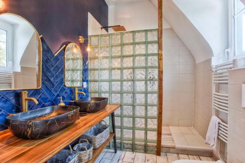 une salle de bain avec deux lavabos et une douche dans l'établissement Villa la Cressonnière, à Deauville